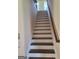 Staircase featuring dark wood treads, white risers, and a stained wood handrail at 200 Parker Dr, Mcdonough, GA 30253