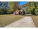 Side view of brick house with driveway and large trees at 1241 Lambeth Se Way, Conyers, GA 30013