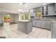 Modern kitchen featuring grey cabinets, granite island, and tile flooring at 1241 Lambeth Se Way, Conyers, GA 30013