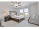 Bedroom featuring a ceiling fan, two windows, and a dark-stained wood bed frame at 704 Chipping Sparrow St, Canton, GA 30115