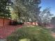 Large fenced backyard featuring green grass, mulch beds, and mature trees offering shade and privacy at 200 Eagle Glen Ct, Woodstock, GA 30189