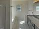 Modern bathroom featuring tiled floors, dark vanity, and a soaking tub underneath a bright window at 200 Eagle Glen Ct, Woodstock, GA 30189