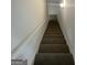 Carpeted stairway leading to the upper level with neutral walls and a simple overhead light fixture at 200 Eagle Glen Ct, Woodstock, GA 30189