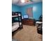 Bedroom with teal walls, bunk beds, and dresser at 9388 Crest Knoll Ct, Jonesboro, GA 30238