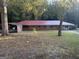 Single story brick home featuring a metal roof, attached carport, and spacious front yard at 10108 Lakeview Sw Dr, Covington, GA 30014