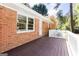 View of the exterior of the house including the stained deck, white railing, and wooded backyard at 504 Milligan Dr, Stone Mountain, GA 30083