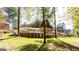 The backyard features a lush lawn, mature trees, and a brick home with a deck, perfect for outdoor enjoyment at 504 Milligan Dr, Stone Mountain, GA 30083