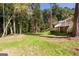 Spacious backyard featuring a well-manicured lawn, mature trees, and a glimpse of the home's exterior with a deck at 504 Milligan Dr, Stone Mountain, GA 30083