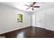 Bedroom featuring ceiling fan, hardwood floors, window, and large closet with bi-fold doors at 504 Milligan Dr, Stone Mountain, GA 30083