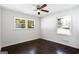 Bright bedroom with a ceiling fan, hardwood floors, and natural light from two large windows at 504 Milligan Dr, Stone Mountain, GA 30083