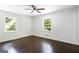 Bright bedroom features a ceiling fan, gleaming hardwood floors, and natural light from two windows at 504 Milligan Dr, Stone Mountain, GA 30083