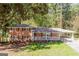 Charming red brick home with mature trees, front porch, and covered carport on a sunny day at 504 Milligan Dr, Stone Mountain, GA 30083
