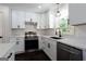 Close-up view of the renovated kitchen with white cabinets, quartz countertops, and stainless steel appliances at 504 Milligan Dr, Stone Mountain, GA 30083