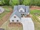 Overhead view of new construction with white exterior, three-car garage and concrete driveway in a wooded area at 241 Ben Horton Dr, Mcdonough, GA 30253