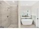 Bright bathroom featuring a glass enclosed shower, modern tile, and a white soaking tub at 241 Ben Horton Dr, Mcdonough, GA 30253