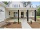 Inviting front porch framed by dark columns, brick accents, and manicured landscaping at 241 Ben Horton Dr, Mcdonough, GA 30253