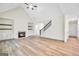 Open concept living room featuring a fireplace, staircase, and wood flooring at 241 Ben Horton Dr, Mcdonough, GA 30253