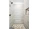 Modern shower featuring gray tile, hexagon mosaic flooring, and convenient built-in niche at 241 Ben Horton Dr, Mcdonough, GA 30253