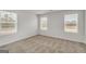 Bright bedroom with neutral walls and carpet, featuring three windows at 209 Weldon Rd # 43, Mcdonough, GA 30253