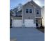 Charming two-story gray home with white trim, two-car garage, and modern black door at 209 Weldon Rd # 43, Mcdonough, GA 30253