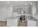 Open kitchen with island, stainless steel appliances, and light wood floors at 209 Weldon Rd # 43, Mcdonough, GA 30253