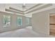 Spacious bedroom with neutral carpet, tray ceilings, and large windows overlooking the backyard at 22 Agean Way, Whitesburg, GA 30185