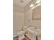 Small half bathroom featuring a pedestal sink, toilet, and framed mirror at 22 Agean Way, Whitesburg, GA 30185