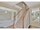 Inviting staircase with wood railings and bright natural light, leading to an open and airy floorplan at 22 Agean Way, Whitesburg, GA 30185