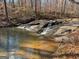 Serene waterfall cascading over rocks in a wooded setting at 785 Seabolt Rd, Locust Grove, GA 30248
