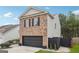 Two-story brick home with a black garage door and side yard at 5602 Waverly Park, Atlanta, GA 30349