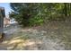 View of the backyard, showing the grassy area, trees, and fencing on the side of the property at 991 Laurel Springs Sw Ln, Marietta, GA 30064