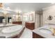 A luxurious bathroom featuring dual vanities, a jetted tub, and elegant fixtures at 7300 Chattahoochee Bluff Dr, Sandy Springs, GA 30350