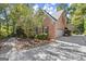 Side view of the brick home featuring a two-car garage and mature landscaping at 7300 Chattahoochee Bluff Dr, Sandy Springs, GA 30350