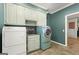 This laundry room has built-in cabinets, a sink, and a front-loading washer and dryer at 7300 Chattahoochee Bluff Dr, Sandy Springs, GA 30350