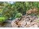 Backyard landscape with a rock water feature surrounded by greenery at 7300 Chattahoochee Bluff Dr, Sandy Springs, GA 30350