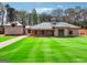 Sprawling single-story home boasts a symmetrical facade, lush lawn, and ample parking with a private, wooded surrounding at 4333 Shiloh Rd, Cumming, GA 30040
