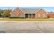 Lovely brick home featuring manicured lawn, green front door, and welcoming front porch at 1115 Oakpark Drive Dr, Mcdonough, GA 30253