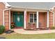 Inviting front porch with charming green door, classic American flag, and cozy seating area at 1115 Oakpark Drive Dr, Mcdonough, GA 30253