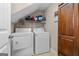 Bright laundry room with front loading washer and dryer plus wooden shelving at 1115 Oakpark Drive Dr, Mcdonough, GA 30253