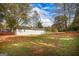View of the house's backyard with trees and fallen leaves at 105 Tranquility Dr, Villa Rica, GA 30180