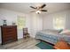 Comfortable bedroom featuring a ceiling fan, wood floors, and natural light from two windows at 105 Tranquility Dr, Villa Rica, GA 30180