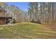 Expansive backyard with lush green grass and towering trees, complemented by deck at 684 Brooks Woolsey Rd, Brooks, GA 30205