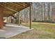 Backyard showing covered patio with stairs leading to the lush lawn and wooded area at 684 Brooks Woolsey Rd, Brooks, GA 30205