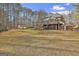 Expansive backyard with lush lawn, mature trees, brick house with upper deck, and storage shed at 684 Brooks Woolsey Rd, Brooks, GA 30205