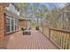 A wooden deck with outdoor seating, grill, and brick exterior, leading to wooded area at 684 Brooks Woolsey Rd, Brooks, GA 30205