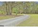 Long gravel driveway leading to a secluded home surrounded by mature trees and landscaping at 684 Brooks Woolsey Rd, Brooks, GA 30205
