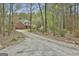 Set back from a gravel drive, a brick home is surrounded by trees and green foliage for privacy and seclusion at 684 Brooks Woolsey Rd, Brooks, GA 30205