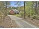 This brick home is surrounded by trees and green foliage, set back from a gravel drive for privacy and seclusion at 684 Brooks Woolsey Rd, Brooks, GA 30205