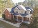 Traditional brick home showcasing a well-manicured front yard with a welcoming front porch at 684 Brooks Woolsey Rd, Brooks, GA 30205
