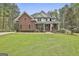 Charming two-story brick and siding home with a lush green lawn and manicured landscaping at 684 Brooks Woolsey Rd, Brooks, GA 30205
